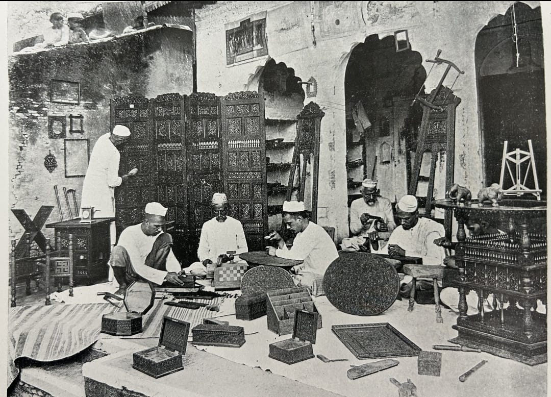 Master Artisans working on carving furniture and handicraft products in a small atelier - old time black & white image