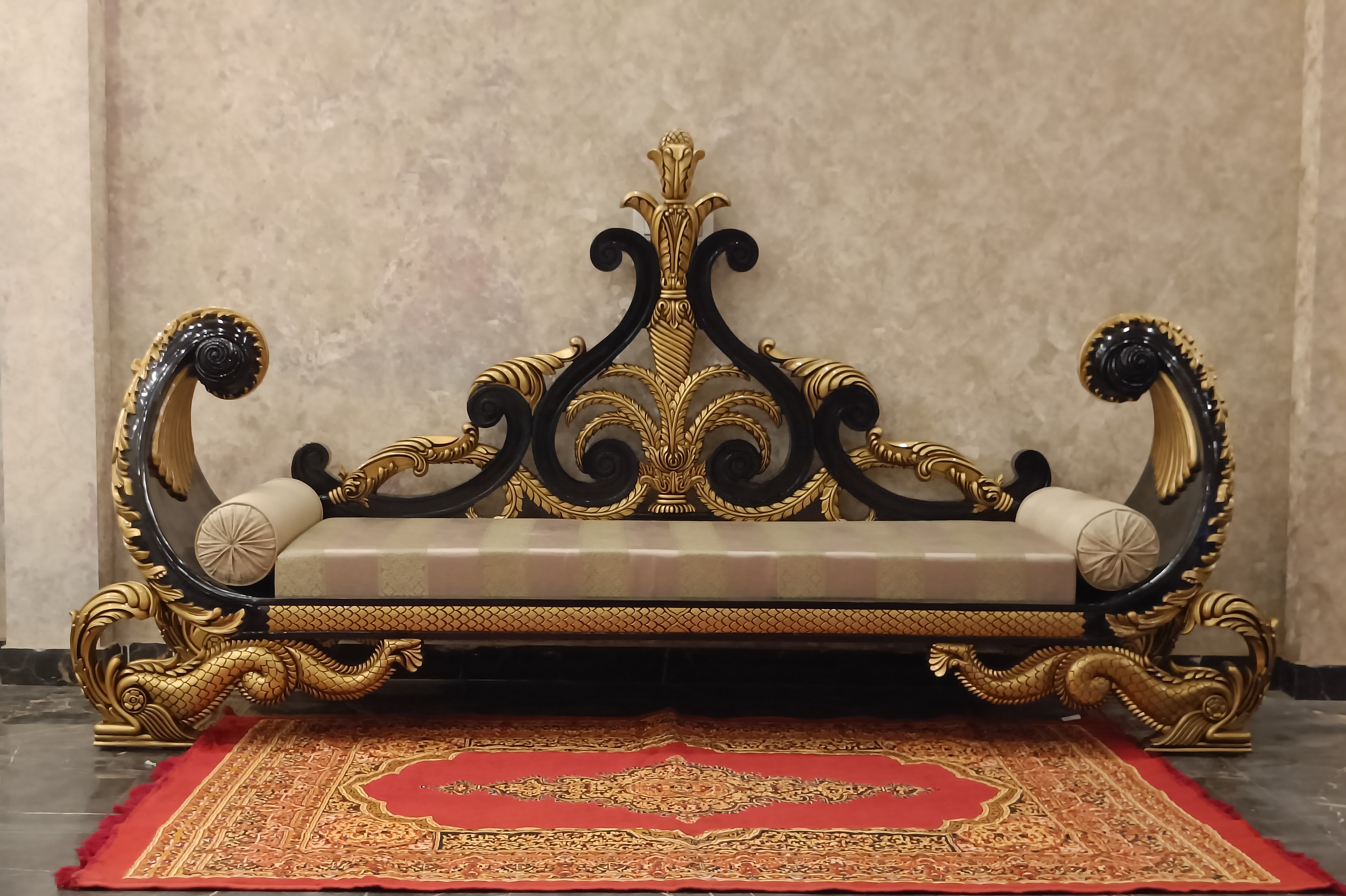 maharaja sofa in teak wood artistic wood carving in royal golden color - luxurious fabric and very comfortable upholstery - adorned with majestic crown - carved by Royalzig luxury furniture  